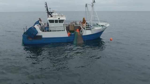 Flying Towards a Commercial Ship Fishing with Trawl Net at the Sea. Shot on RED Cinema Camera in 4K (UHD). 