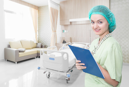Nurse writing medical records in modern hospital room with beds