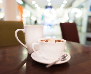 Two White cups of cocoa or coffee with marshmallow. Restaurant background