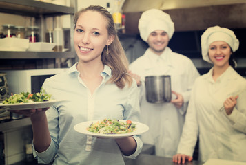 Waitress with plates at kitchen
