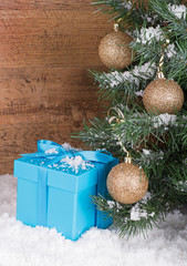 Blue Christmas Gift Box in Snow Under a Tree