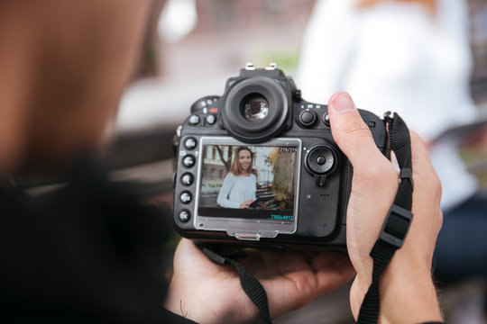 Photo camera holded by man photographer taking photos of woman