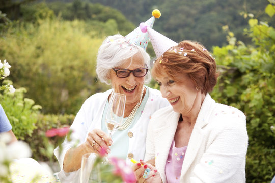 Senior ladies drinking champagne at birthday party