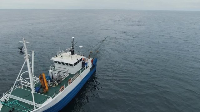 Flying over a Commercial Fishing Ship that Pulls Trawl Net.  Shot on RED Cinema Camera in 4K (UHD). 