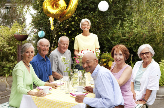 Senior people celebrating birthday in garden