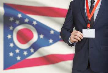 Businessman holding badge on a lanyard with USA state flag on background - Ohio