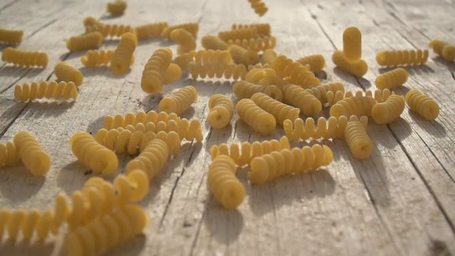 nudeln fallen auf holzboden in slowmotion