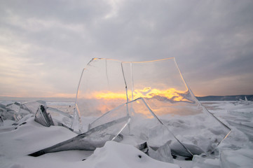 Magic winter sunset shining through the ice of lake Baikal