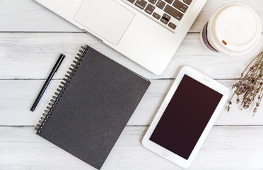 White office desk with laptop, smartphone, notebook on wooden table. Top view with copy space. Student or business accessories flatlay. Office supplies and gadgets on background. View from above.
