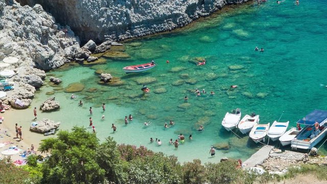 People on Sandy Beach at St Paul's Bay in Londos on Rhodes Greece Swimming in Crystal Clear Blue Mediterranean Water Next to Big Rocks on a Sunny Day during Summer in the Mediterranean