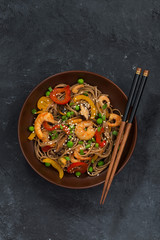 Buckwheat noodles with seafood in a bowl, vertical, top view