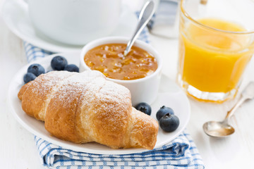 croissant with orange jam, blueberries and coffee 