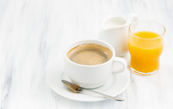 Fototapeta cup of coffee and  orange juice on white table