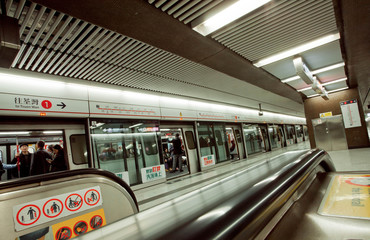 Interior of the underground station of asian city and passengers inside trains