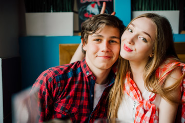 Group of young friends hanging out at a coffee shop. Young men and women meeting in a cafe having fun. Lifestyle, friendship and urban life concepts.