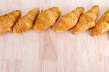 fresh croissants on wooden table.