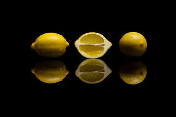 Three  yellow lemons on black background
