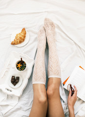 Flat lay shot of Soft photo of woman on the bed with cup of herb
