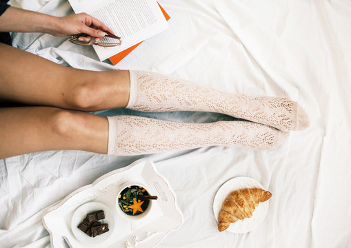 Flat lay shot of Soft photo of woman on the bed with cup of herb