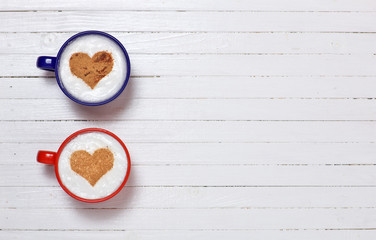 Two cups of coffee with heart shape symbol 