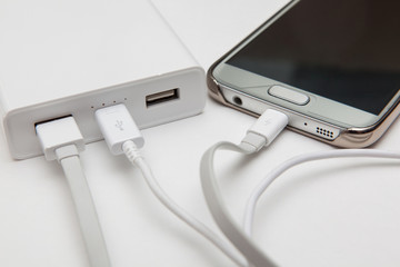 charging smart phone with portable battery on white backgrounds