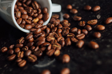 Espresso cup full of coffee on the grains pile. Italian traditional morning short drink on breakfast. Close-up. Toned