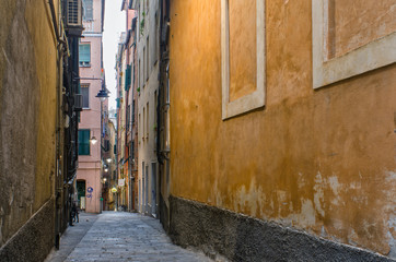 View along the walls into the descending narrow street of Vico Salvaghi in the ancient part of the city of Genoa, a world of its own