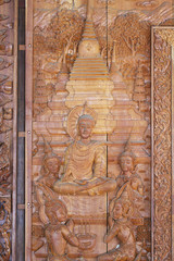 A wooden carving of seated buddha and temple, Thailand 
