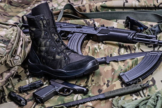 Military boot and weapon.Selective focus/One army boot, pistol, rifle, knife ammo and other ammunition.