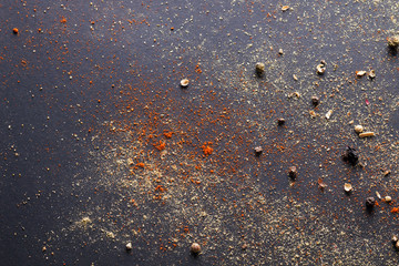 Spicy background with assortment of different hot chili peppers and mix of other spices on a dark background