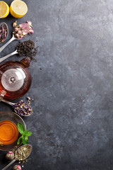 Tea cup, teapot and assortment of dry tea in spoons