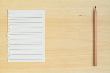 Empty paper note with pencil on wood background