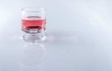 Pink wine in stemmed glasses on white background with copy space