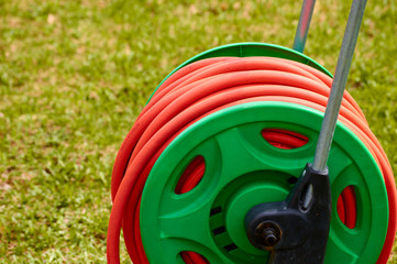 orange rubber hose in the garden on the grass