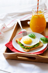 Sandwich with fried egg and orange juice