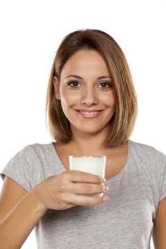 beautiful young woman holding a glass of milk