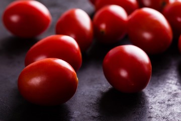 Detail of several red cherry tomatoes on black board