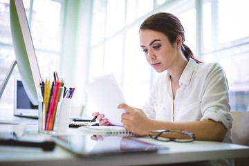 Serious graphic designer writing on document