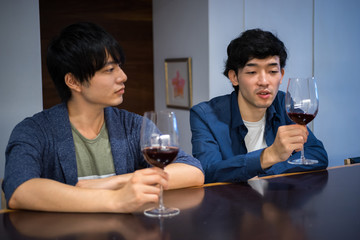 会話しながらワインを飲む2人の男性