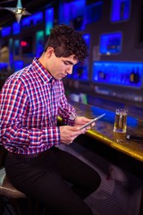 Man using digital tablet at bar counter