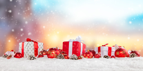 Christmas gift boxes and balls on snow.