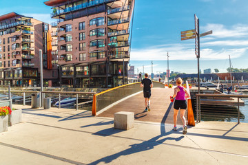 Fitness, sport, exercising and healthy lifestyle concept - woman and man running or jogging over oslo city street background. - obrazy, fototapety, plakaty