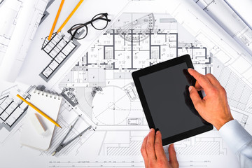 Naklejka na ściany i meble Construction plans and Male Hands using a Tablet on blueprints;
