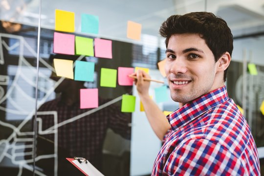 Businessman writing on sticky notes