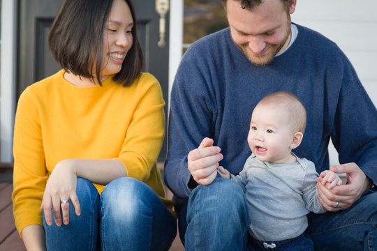 Young Mixed Race Chinese and Caucasian Family Portrait On Their Front Porch.