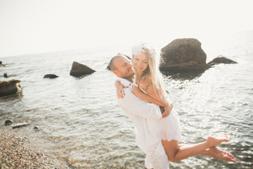happy just married young wedding couple celebrating and have fun at beautiful beach sunset