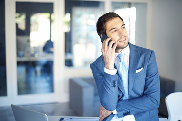 Financial professional man. Shot of a young businessman making call while working at office