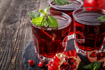 Glasses of pomegranate juice with fresh pomegranate fruits