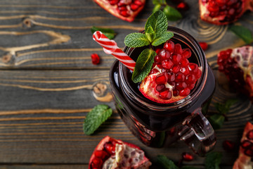 Glasses of pomegranate juice with fresh pomegranate fruits