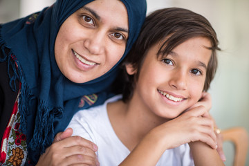 Muslim traditional woman with son at kitchen